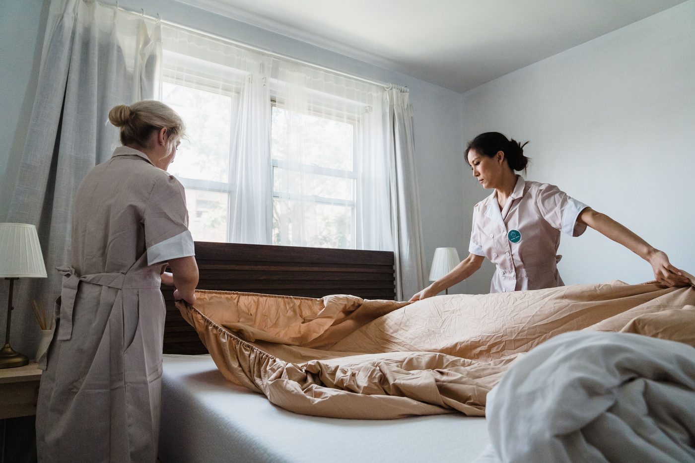 Professional housekeeping staff preparing a bedroom — housekeeping services in Secunderabad